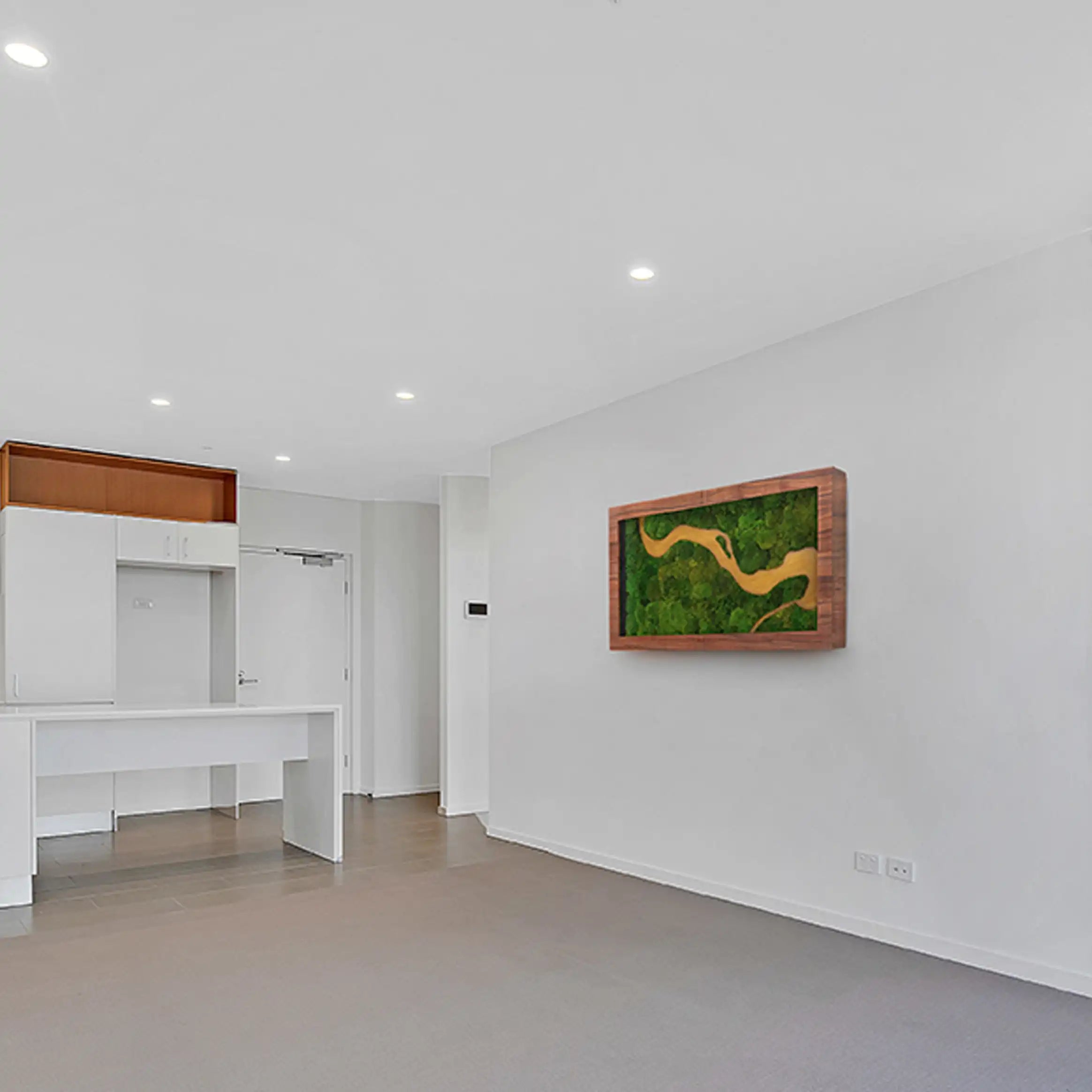 Sala de estar minimalista con un cuadro decorativo de musgo preservado en la pared.